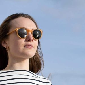 woman wearing sustainable sunglasses outdoors to make a positive change