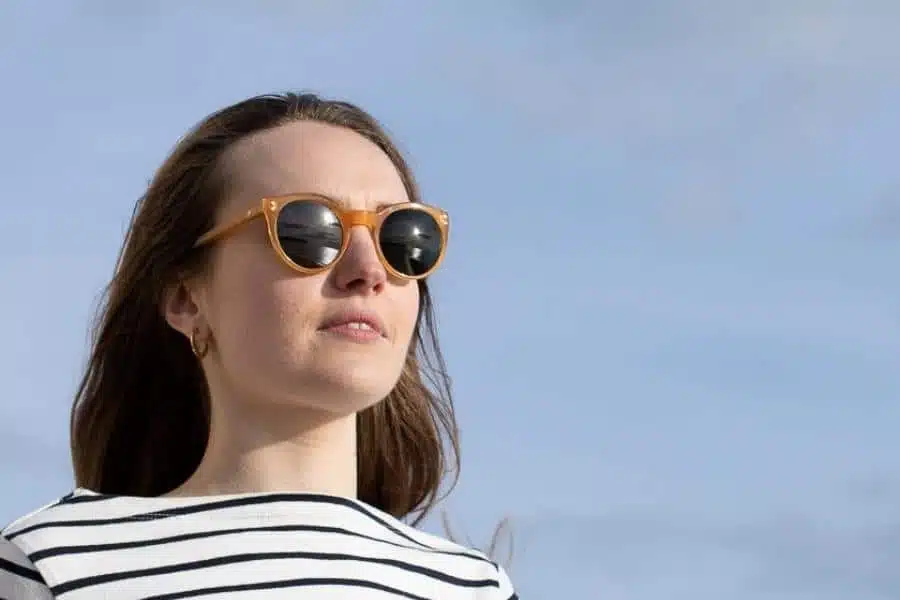 woman wearing sustainable sunglasses outdoors to make a positive change