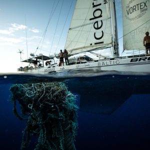 plastic waste in sea beside yacht
