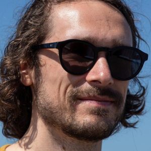 Man wearing round recycled black sustainable sunglasses