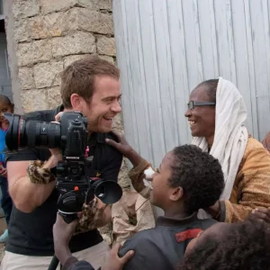 Photographer sharing picture and laughing with female in Ethiopia