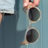 woman holding transparent round sunglasses