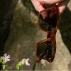square brown ethical sunglasses held in hand
