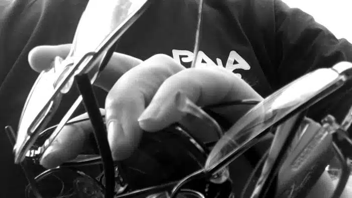 Person holding old spectacle frames for recycling