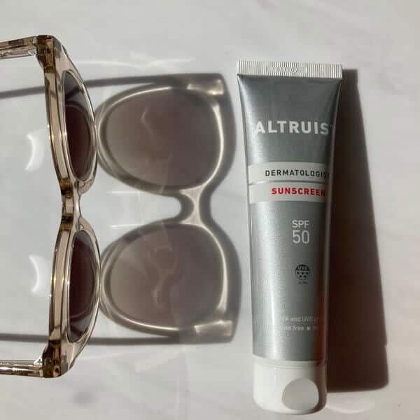 Bottle of SPF 50 Alturist Sunscreen with Pala Sunglasses