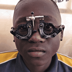 Young africa boy having his eyes tested by an optometrist in Zambia
