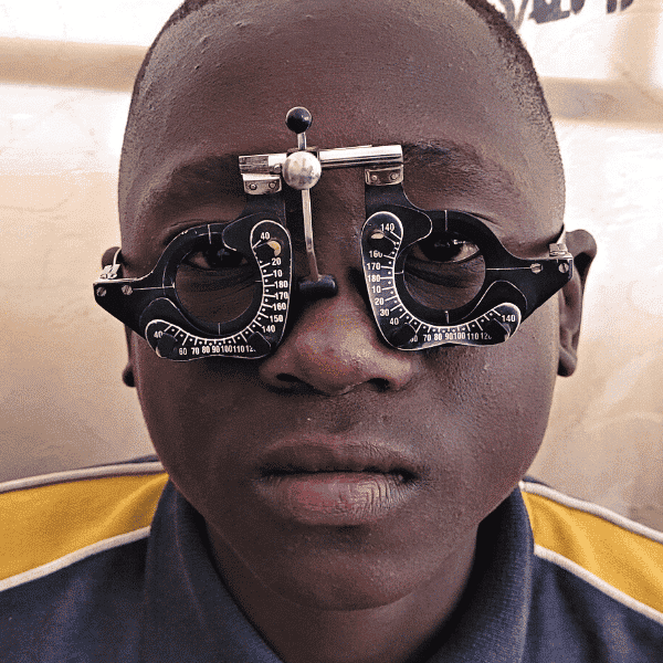 Young africa boy having his eyes tested by an optometrist in Zambia