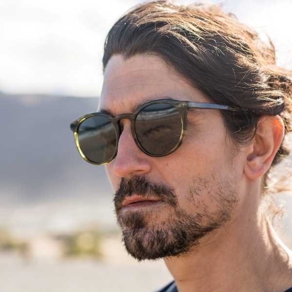 Man wearing round green ethical sunglasses