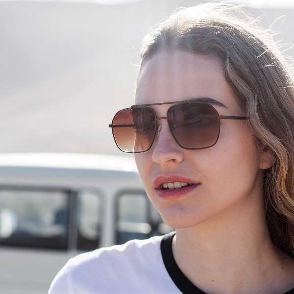 woman wearing angular aviator sunglasses with brown lenses
