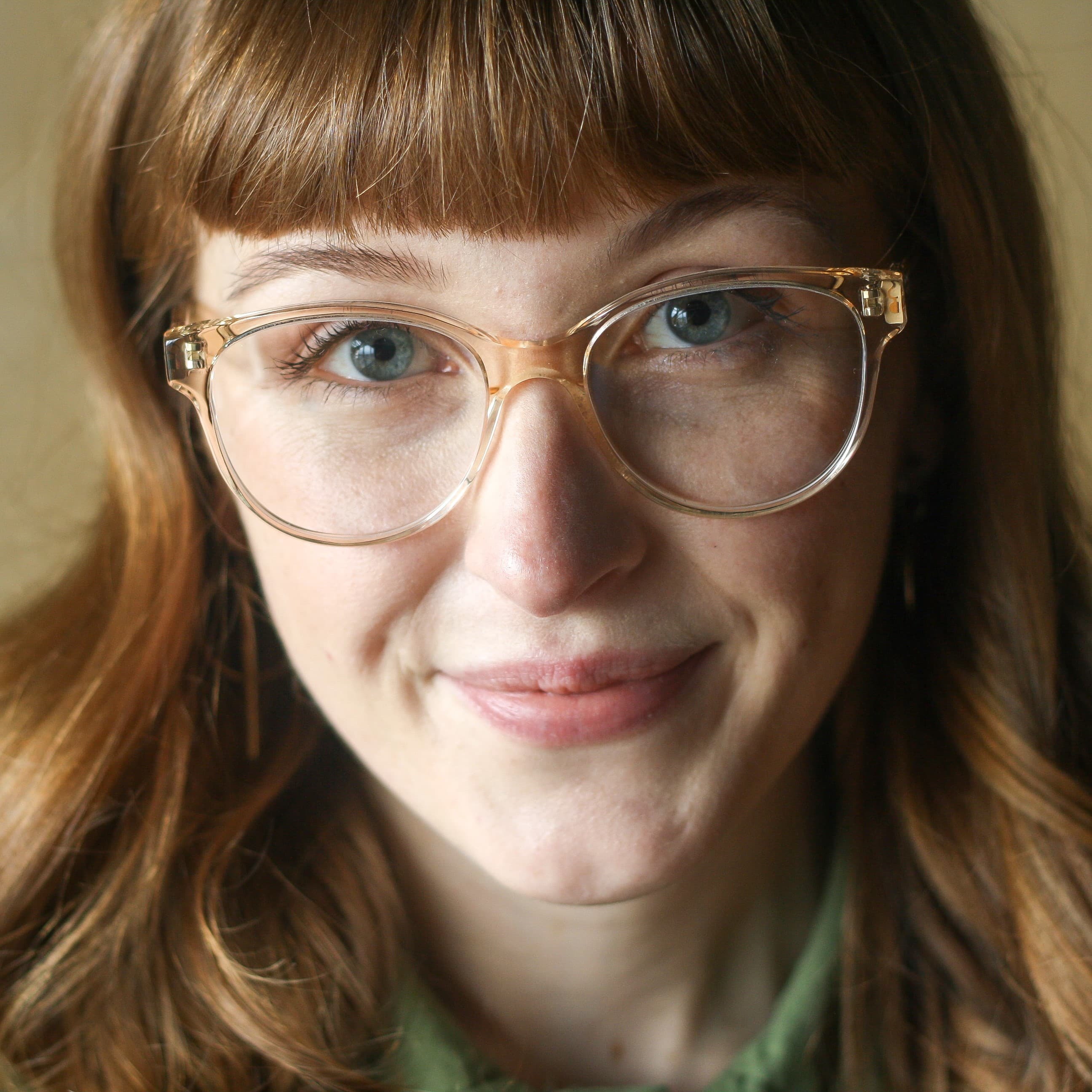 woman wearing oversized feminine glasses with a sweeping brow line in crystal citrine. Handmade in Italy from eco-friendly bio-acetate.