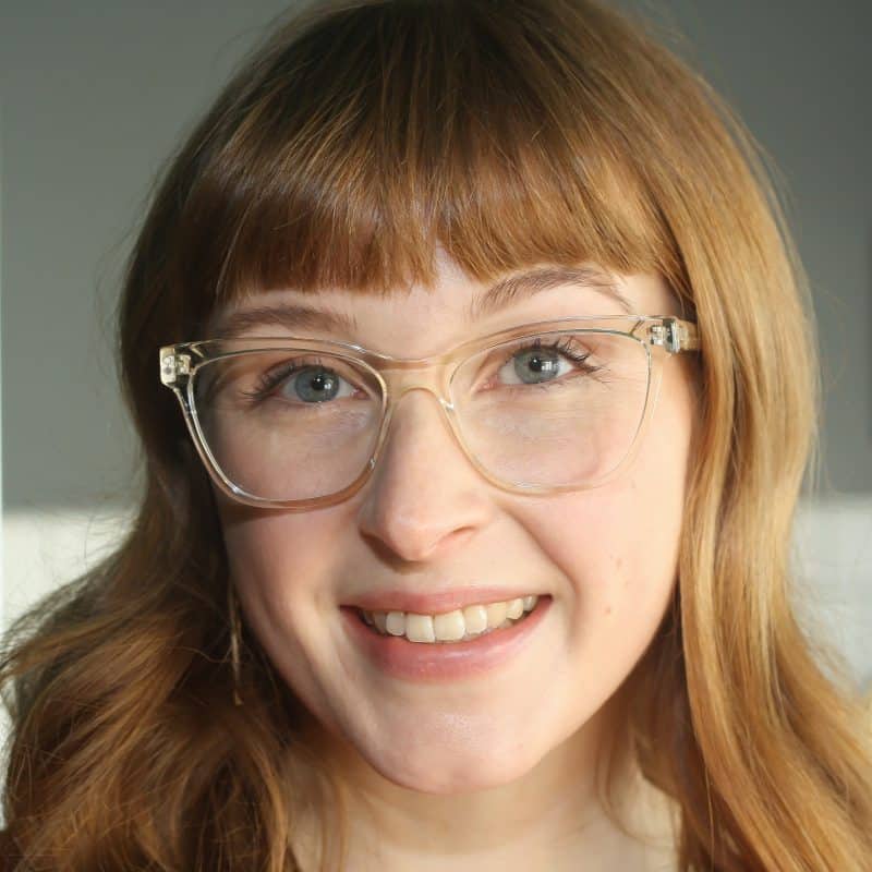 Woman wearing blue light blocking glasses in a clear cat eye shape.