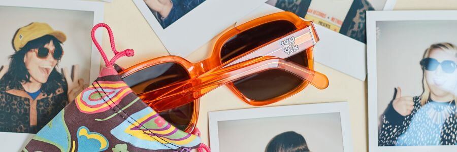Close up of Lucy and Yak x Pala 70's Square Haiba frame in Burnt Orange Acetate, surrounded by polaroid's. 